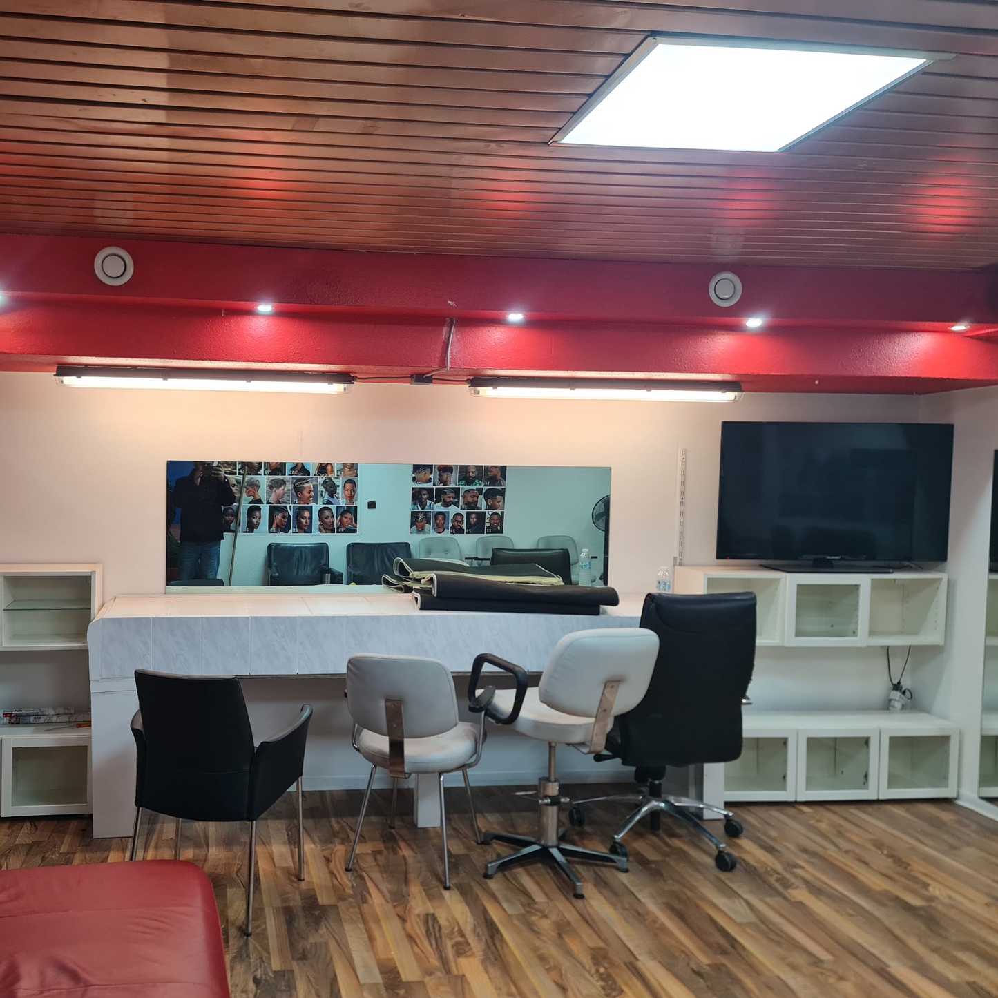 Modern office space with red ceiling, white walls, and wooden floor.