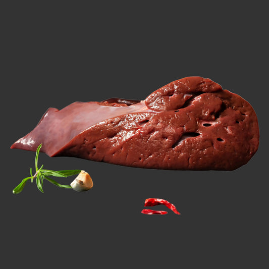 Raw liver on a dark surface with spices and herbs
