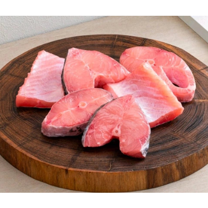 Raw fish fillets on a wooden cutting board