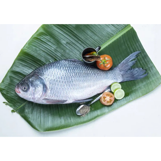 Raw fish on a banana leaf with vegetables and spices