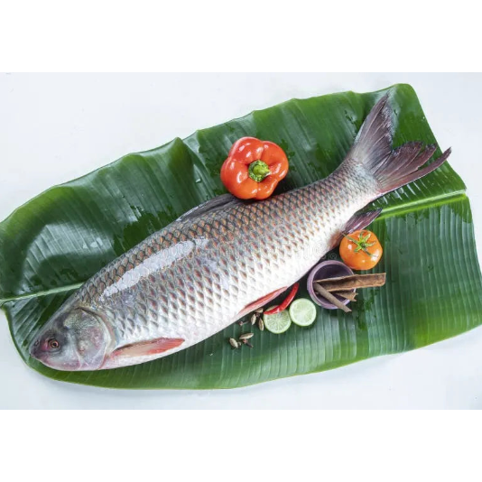 Fish on a banana leaf with vegetables on a white background