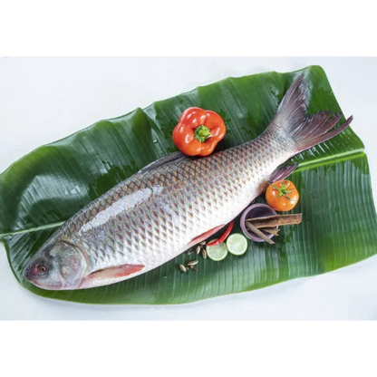 Fish on a banana leaf with vegetables on a white background